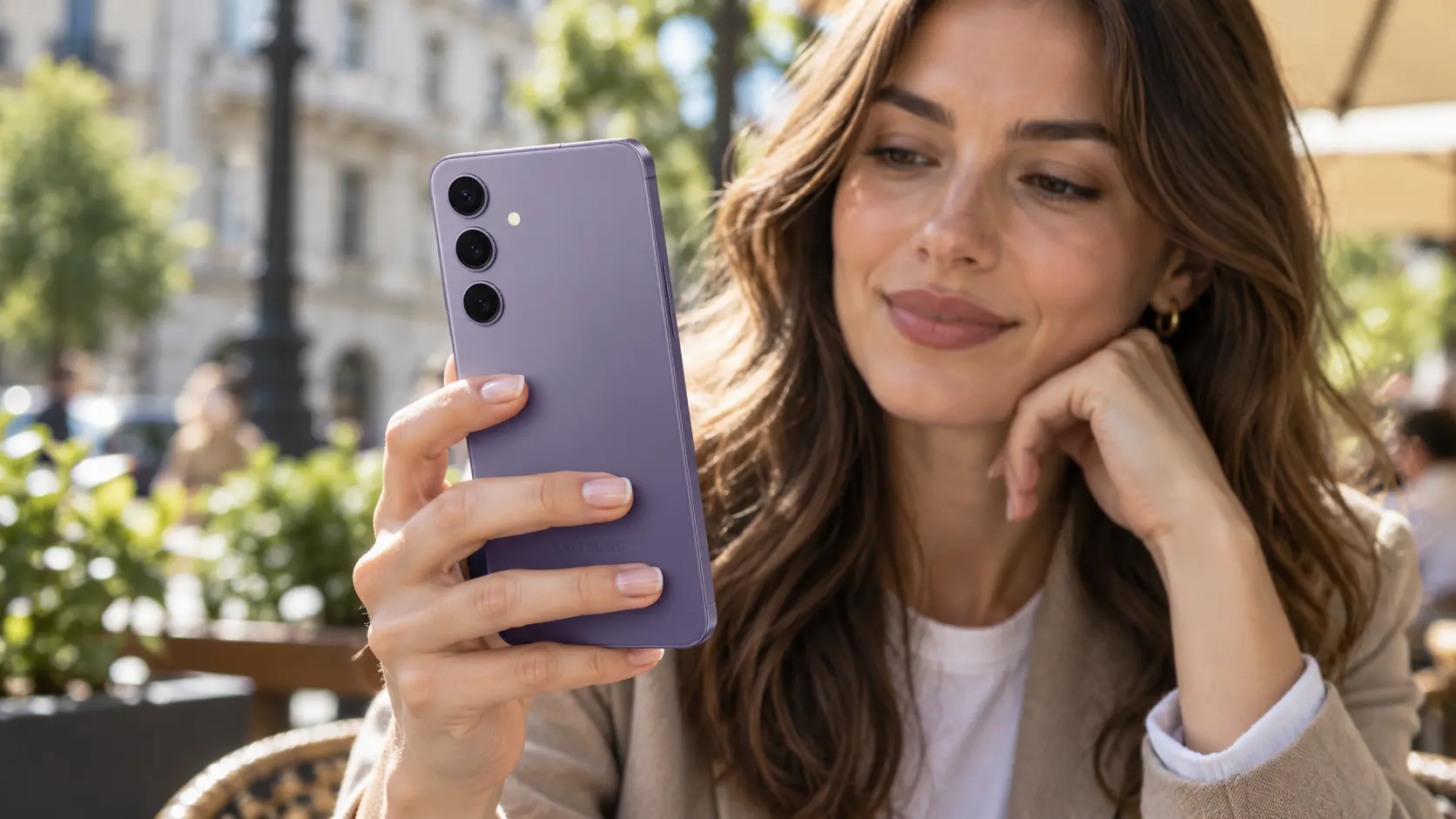 Žena koristi ljubičasti Samsung S24 jednom rukom u kafiću.